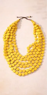 Collar largo de múltiples capas compuesto por discos circulares de madera en color negro, con diseño orgánico y liviano.