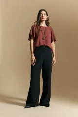 Pantalón de vestir negro de corte ancho y silueta recta, con diseño de tiro medio y bolsillos laterales. Presenta una caída fluida y estructurada, ideal para un look formal o de oficina.