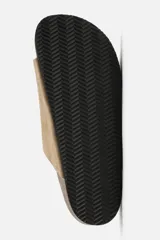 Sandalia color beige fabricada en piel con acabado serraje. Cuenta con dos tiras anchas ajustables mediante cierres adherentes y plantilla con horma anatómica.