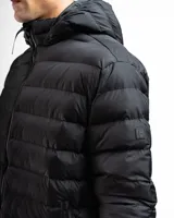 Campera acolchada tipo puffer color negro, con capucha integrada, cierre frontal completo y bolsillos laterales con cierre. Presenta puños y cintura con terminaciones elásticas para un mejor ajuste.
