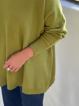 Sweater de punto color verde pistacho, con cuello redondo, mangas largas con puños ajustados y diseño holgado de corte oversize.