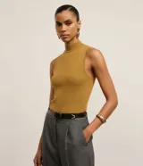 Blusa de punto acanalado color mostaza, sin mangas, con cuello alto y diseño ajustado al cuerpo.