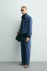 Cazadora de denim de algodón con corte relajado, cuello solapa, cierre frontal de botones y mangas largas con puños abotonados. Presenta bolsillos de solapa en el pecho y bolsillos laterales de vivo, con un acabado de efecto lavado.