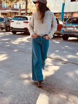 Pantalón de jean ancho de color azul, con bordado de las iniciales AW en el bolsillo trasero.