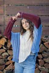 Sweater de punto con diseño de ochos y estilo patchwork, combinando paneles en colores terracota, marrón y beige. Presenta cuello redondo, mangas largas y costuras decorativas a la vista.