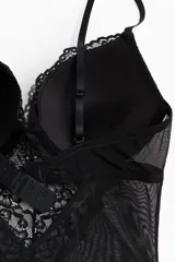Body colaless negro confeccionado en encaje y malla transparente, con soutien push-up, copas acolchadas con aros y breteles regulables.