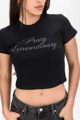 Remera crop gris oscura con estampa frontal en tono claro con la frase "Pretty Extraordinary".