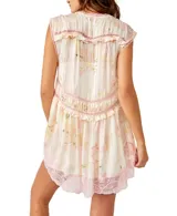 Vestido corto blanco con estampado floral en tonos pastel y detalles de encaje rosa. Tiene escote en V, botones frontales y volantes.