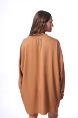 Vestido camisero color marrón claro, de corte oversized, manga 3/4 con puños elásticos y cierre frontal con botones a tono.