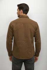 Camisa de jean con efecto lavado, manga larga, cuello clásico y cierre frontal con botones. Presenta dos bolsillos frontales con solapa y botones.