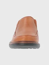 Zapato tipo mocasín de cuero color tostado, con diseño de costuras reforzadas y suela de goma EVA en color negro.