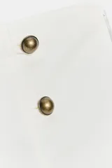 Short mini de tiro bajo color blanco con aplicación de botones dorados frontales y cierre lateral con cremallera oculta.