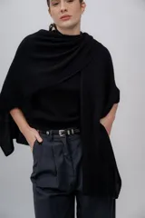 Ruana negra de tejido de punto grueso, confeccionada en 100% baby alpaca.