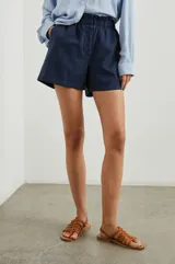 Short azul marino de tiro alto con cintura paperbag, bragueta con botones y cintura elástica.