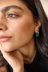 Aros dorados con dije circular de piedra natural negra.