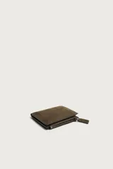 Cartera vertical para hombre fabricada en piel con acabado de serraje, en color verde militar. Dispone de un compartimento principal para billetes, seis posiciones internas para tarjetas y un compartimento para monedas con cierre de cremallera.