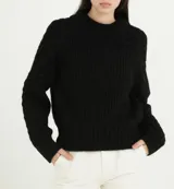 Sweater de punto negro con cuello redondo, diseño de trenzas en las mangas y tejido acanalado en el cuerpo y puños.