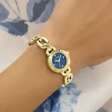 Reloj Guess modelo Siren con caja de 22 mm en acero inoxidable dorado. Presenta una esfera azul con acabado sunray, bisel con cristales incrustados y correa tipo brazalete de eslabones dorados.