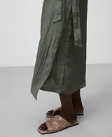 Falda midi color verde oliva con textura arrugada, corte pareo y cierre lateral con cremallera.