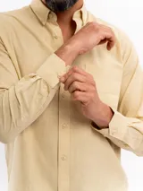 Camisa de manga larga con efecto lino, color azul, cuello con botones y bolsillo ojal en el pecho.