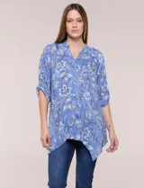 Blusa azul con estampado floral, escote en V, abotonadura frontal y mangas tres cuartos con presilla para arremangar. Cuenta con un diseño amplio y ruedo asimétrico en punta.