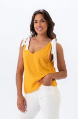 Musculosa mostaza con breteles anchos que se atan en los hombros.
