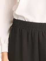 Pantalon de corte wide leg en color gris, con cintura elastizada y franjas laterales en contraste. Presenta un diseño de pierna recta y holgada.