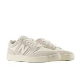 Championes New Balance Numeric 480 de estilo retro, confeccionados en una combinación de gamuza y cuero en tonos crema y blanco. Presentan el logo N en el lateral, suela de goma plana y perforaciones en la puntera para mayor ventilación.