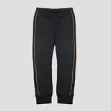 Pantalon de jogging Umbro color negro, con cintura elástica con cordón ajustable, puños acanalados en los tobillos y detalles de líneas verticales en color naranja a lo largo de las piernas. Presenta el logo de la marca bordado en color naranja en la parte superior.
