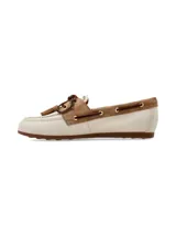 Mocasín de cuero estilo náutico, en combinación de color crema y marrón gamuzado. Presenta detalles de costuras artesanales, cordones de cuero cruzados con ojales metálicos, flecos y borlas decorativas en el empeine.