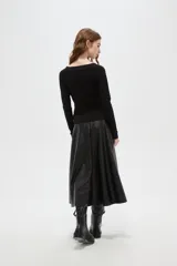 Top de manga larga color negro, confeccionado en poliéster, con diseño drapeado frontal y cuello en V.