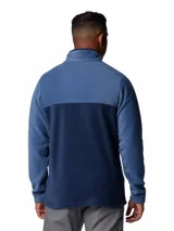 Buzo polar de fleece con diseño de medio cierre frontal con botones a presión. Presenta un diseño bicolor en tonos azul, con cuello alto y logo de la marca bordado en el pecho.