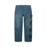 Pantalón tipo carpintero Supreme Leather Appliqué Painter de color azul, con ajuste regular fit y detalle de apliques de letras en la pierna izquierda.