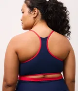 Top deportivo Get Over de corte nadador, confeccionado en microfibra azul marino con detalles en color rojo en los bordes y breteles. Presenta escote en U y copas integradas.