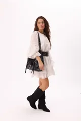 Bolso bandolera negro de símil cuero con múltiples cierres, tachas plateadas y detalle de hebilla tipo cinturón al frente.