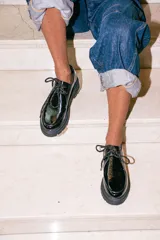 Zapatos tipo wallabee de cuero metalizado en tono peltre, con cordones negros y suela track de goma negra con plataforma.