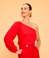 Blusa roja de lino con un solo hombro y manga larga abullonada.