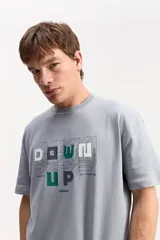Remera oversize de manga corta, color gris, con calce amplio y estampa frontal con letras en relieve visual y marca Mistral.
