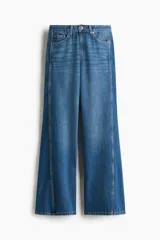 Jean de tiro alto y corte acampanado, confeccionado en denim de algodón. Presenta diseño de cinco bolsillos, cierre frontal con botón y costuras decorativas laterales.