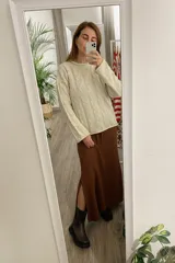 Sweater tejido color arena con diseño de espiga, cuello redondo y mangas largas.