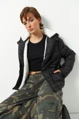 Campera puffer negra de nylon con capucha y peluche en el interior.