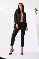 Pantalón negro de vestir con corte cigarette, tiro medio y ruedo doblado.