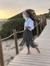 Falda midi gris de punto acanalado con flecos largos en cascada, confeccionada en hilado de algodón.