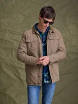 Campera de gabardina color azul marino, con cuello camisero, cierre frontal con botones metálicos y bolsillos frontales con solapa.