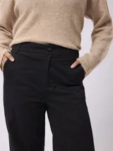Pantalón de corte recto y tiro medio, confeccionado en gabardina de algodón con un toque de elastano. Presenta cierre frontal con botón y bolsillos laterales.