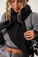 Bufanda negra capitoneada con terminación en pico y costuras decorativas.