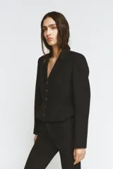 Blazer corta negra de la colección Zara Woman, con cuello solapa de muescas y manga larga. Presenta detalles de pespuntes marcados y forro interior a tono. Cierre frontal con botones.