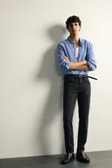 Jeans slim fit de tiro medio, color celeste claro con efecto lavado. Confeccionados en tejido elástico, cuentan con diseño de cinco bolsillos y cierre frontal con cremallera y botón metálico.