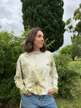 Buzo amplio de frisa liviana de algodón color gris con estampado botánico de hojas en tonos verdes. Tiene cuello redondo y tajos laterales.