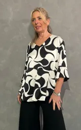 Blusa de manga larga con cuello en V, con estampado abstracto en color blanco y negro.